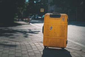 yellow plastic trash bin on sidewalk during daytime